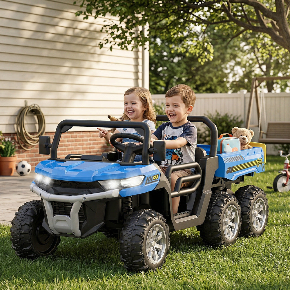 Two children playing in a blue toy truck on a grassy area.